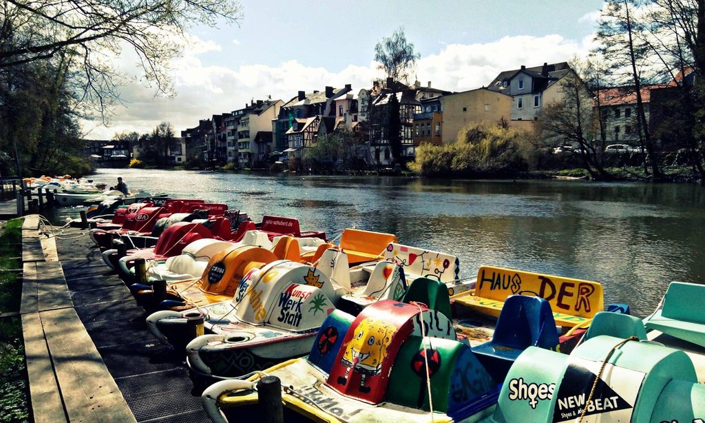 Reihe bunter Tretboote am Quay-Ufer mit Fachwerkhäusern der Marburger Altstadt