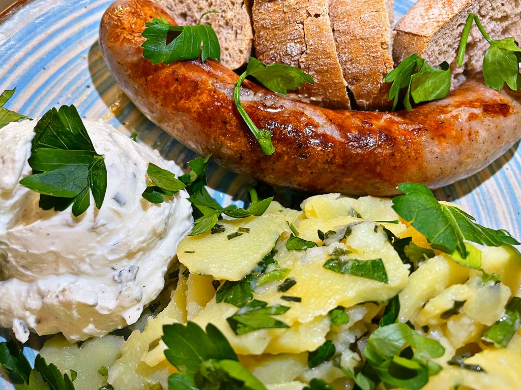 Gegrillte Bratwurst mit frischem Brötchen, Kartoffelsalat und Kräuterquark