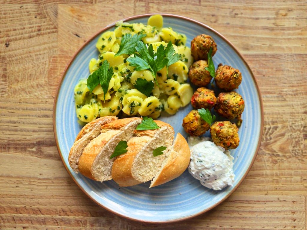 Sommerteller mit Falafel-Bällchen, Brot, Kartoffelsalat und Kräuterquark