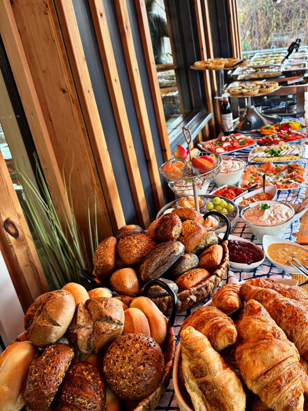 Festliches Frühstücksbuffet mit Brotkörben, Croissants und Obst-Etagere