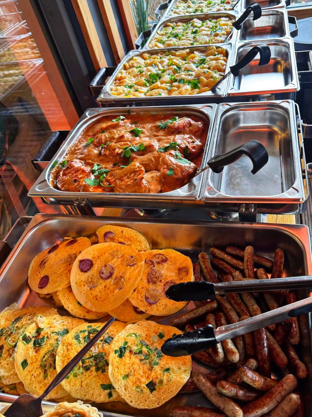 Warmes Buffet mit Pasta-Gratin, Eintopf und Beilagen auf der Terrasse
